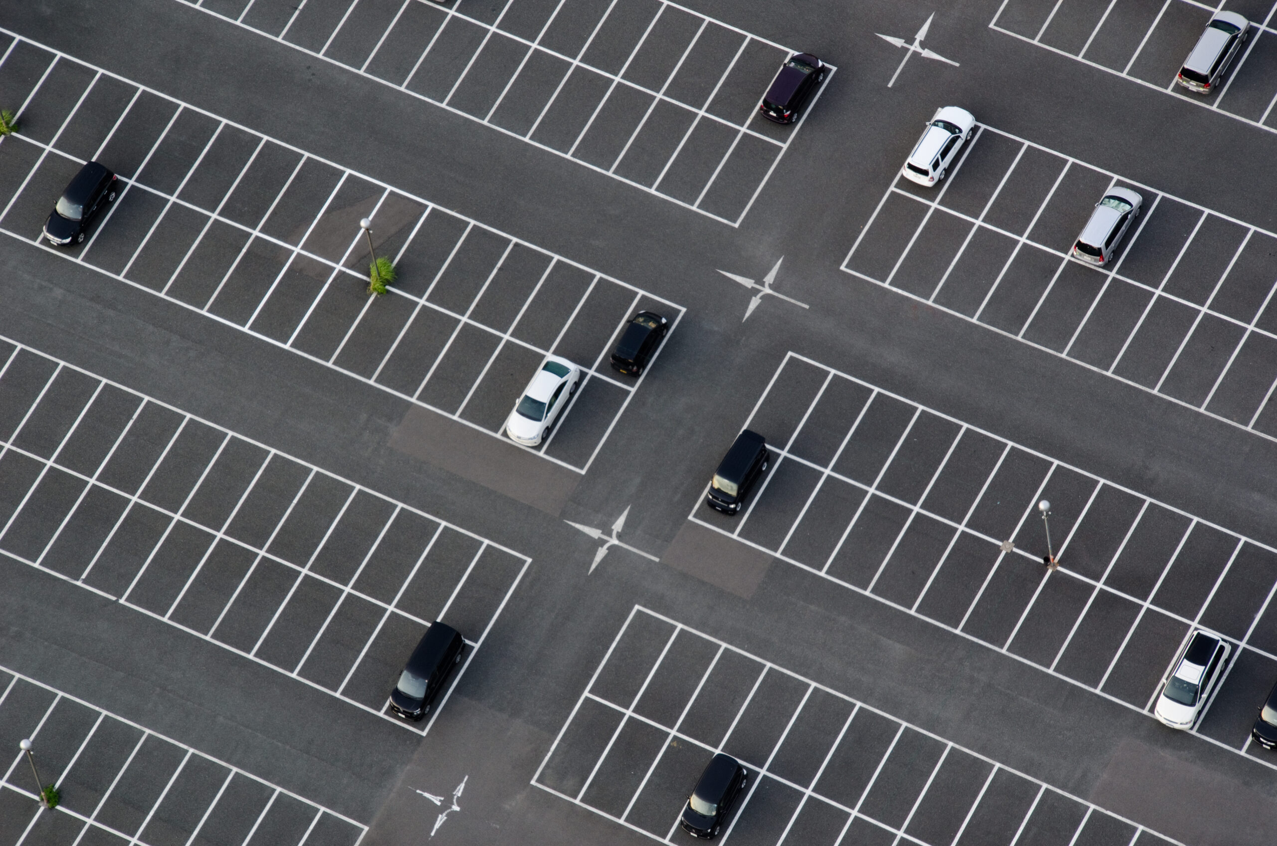 Aerial view of an asphalt commercial parking lot in the summer sun